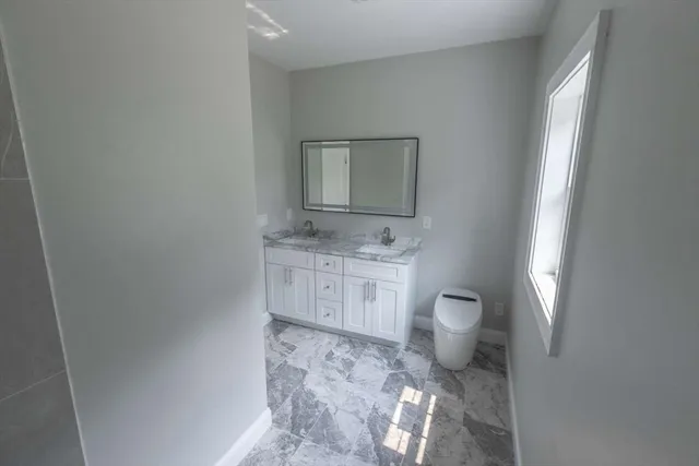 a bathroom with a toilet sink and mirror