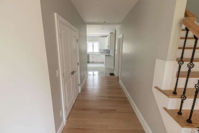 a view of a hallway with wooden floor and staircase