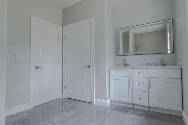 a bathroom with a sink vanity and mirror
