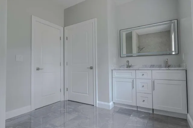 a bathroom with a sink vanity and mirror