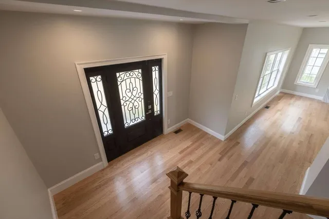 a view of a hallway with wooden floor and stairs