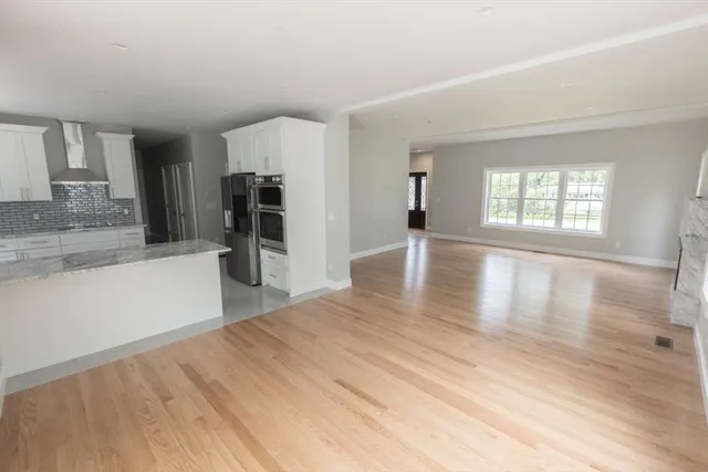 an empty room with wooden floor and a window