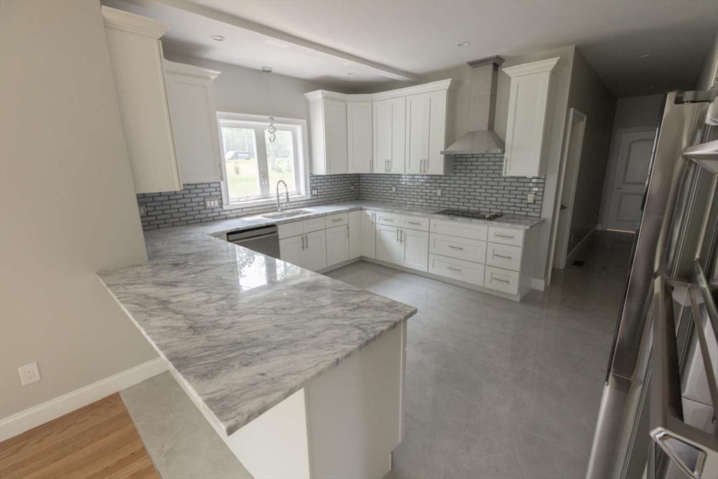 217 Prospect Street Auburn, MA 01501 - Photo 9 of 41 a kitchen with stainless steel appliances granite countertop a sink refrigerator and cabinets