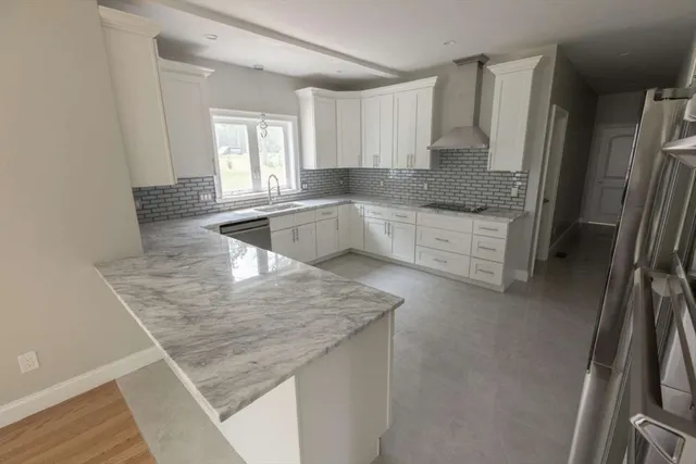 a kitchen with stainless steel appliances granite countertop a sink refrigerator and cabinets