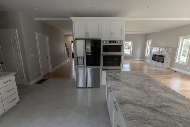 a kitchen with stainless steel appliances kitchen island granite countertop a refrigerator and a stove top oven