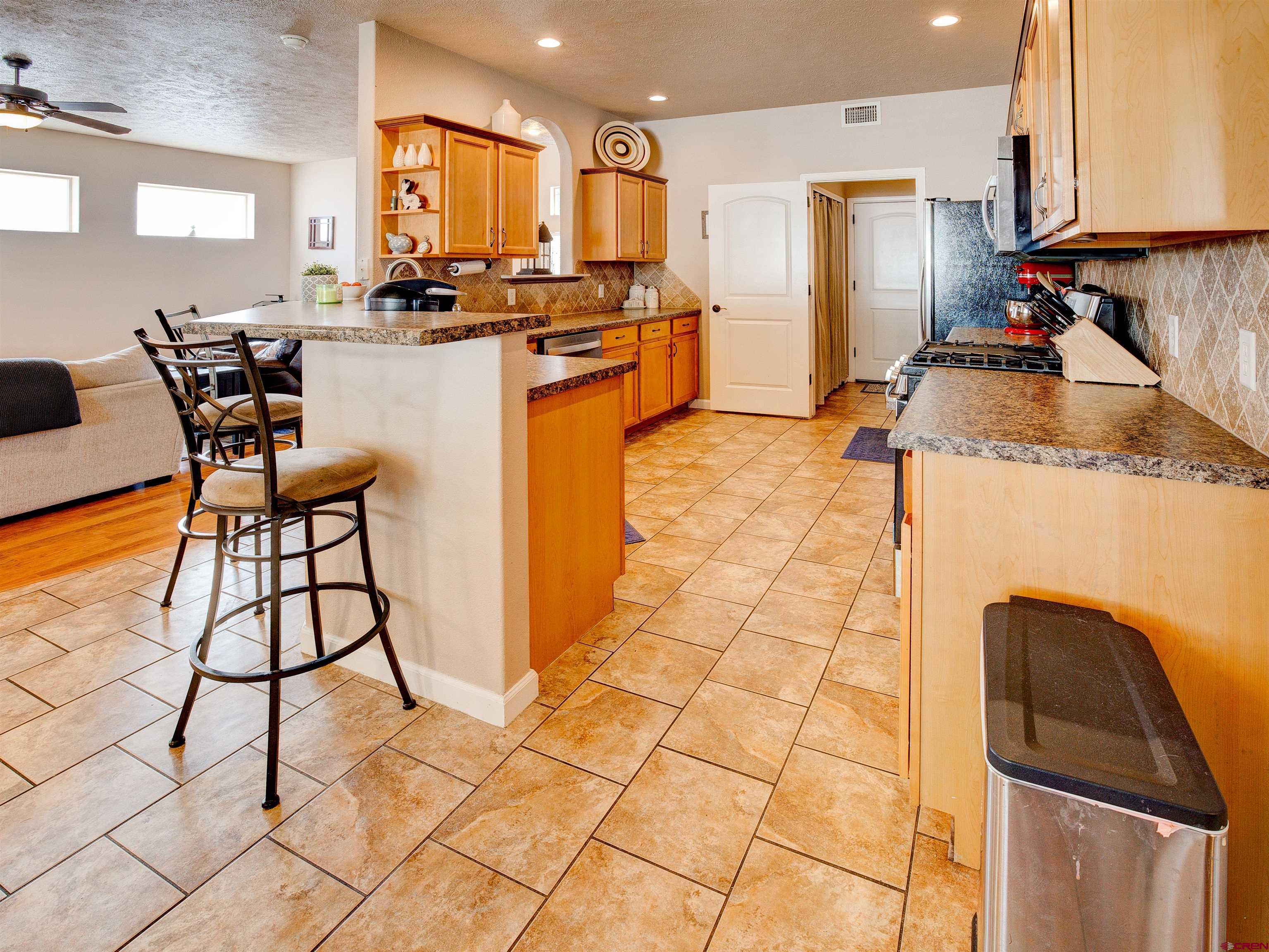 2942 F 1/4 Road Grand Junction, CO 81504 - Photo 11 of 32 a kitchen with stainless steel appliances granite countertop sink stove and cabinets