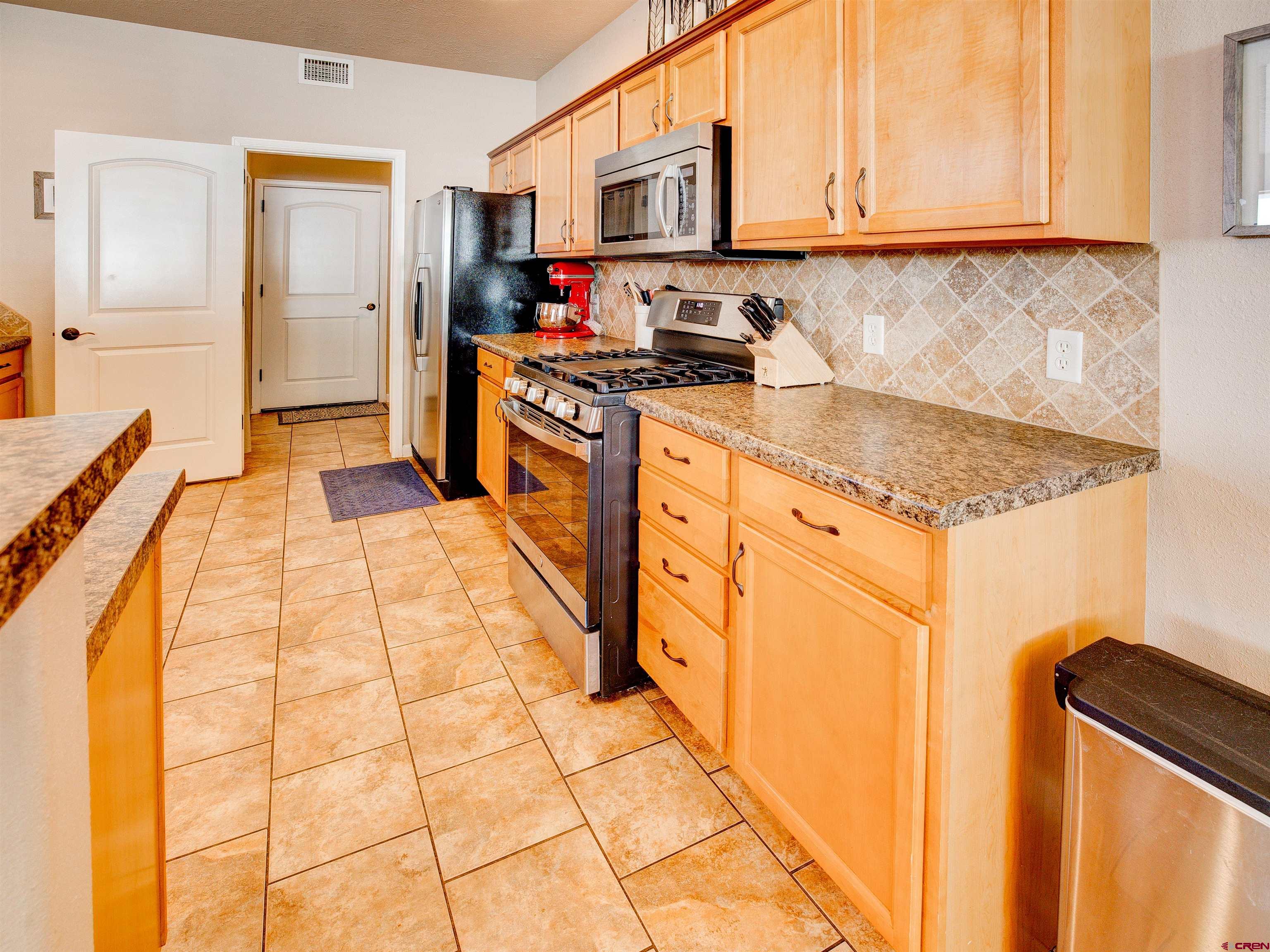 2942 F 1/4 Road Grand Junction, CO 81504 - Photo 12 of 32 a kitchen with stainless steel appliances granite countertop a stove and a sink