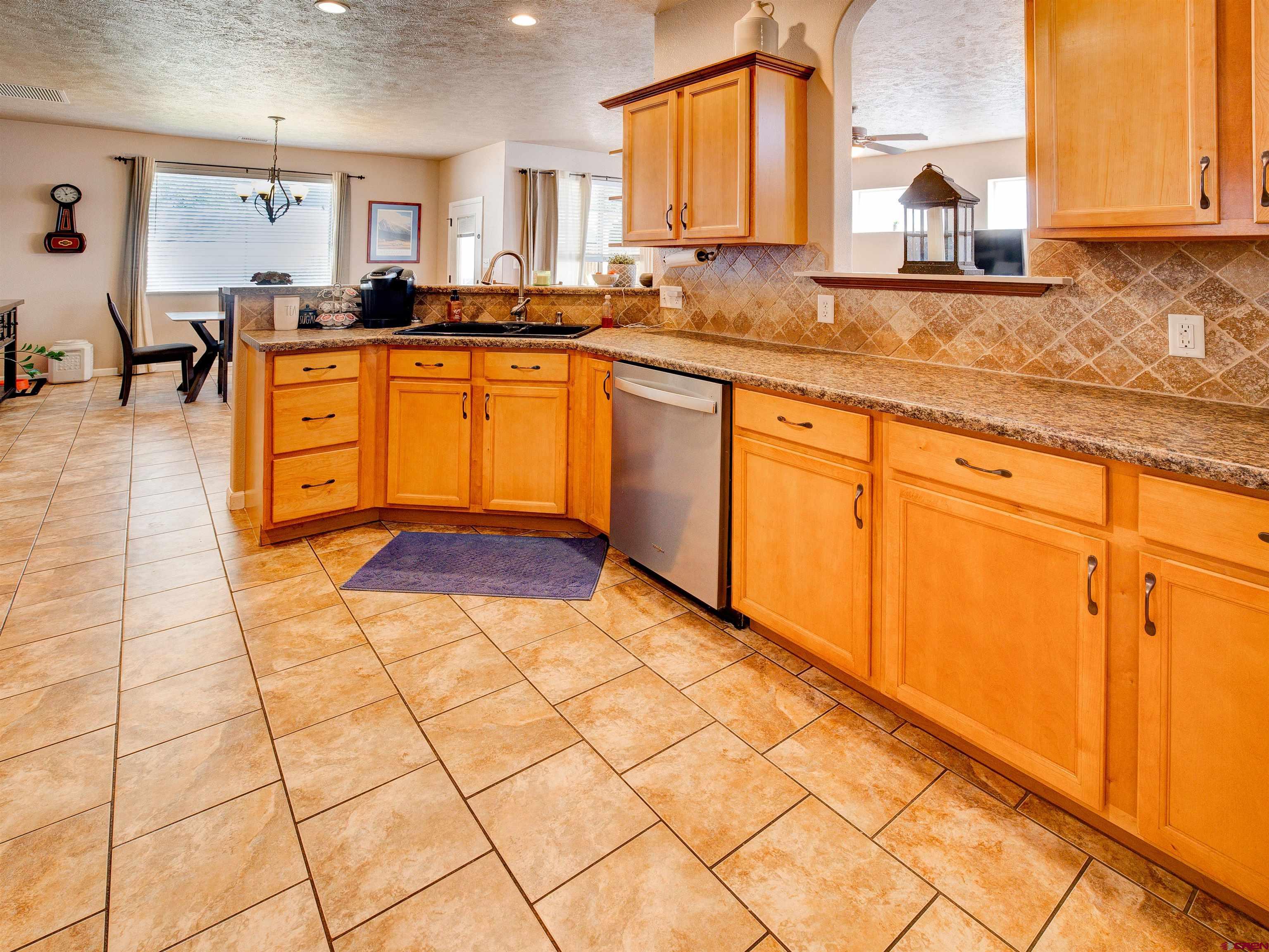2942 F 1/4 Road Grand Junction, CO 81504 - Photo 13 of 32 a kitchen with stainless steel appliances granite countertop a stove a sink and a microwave