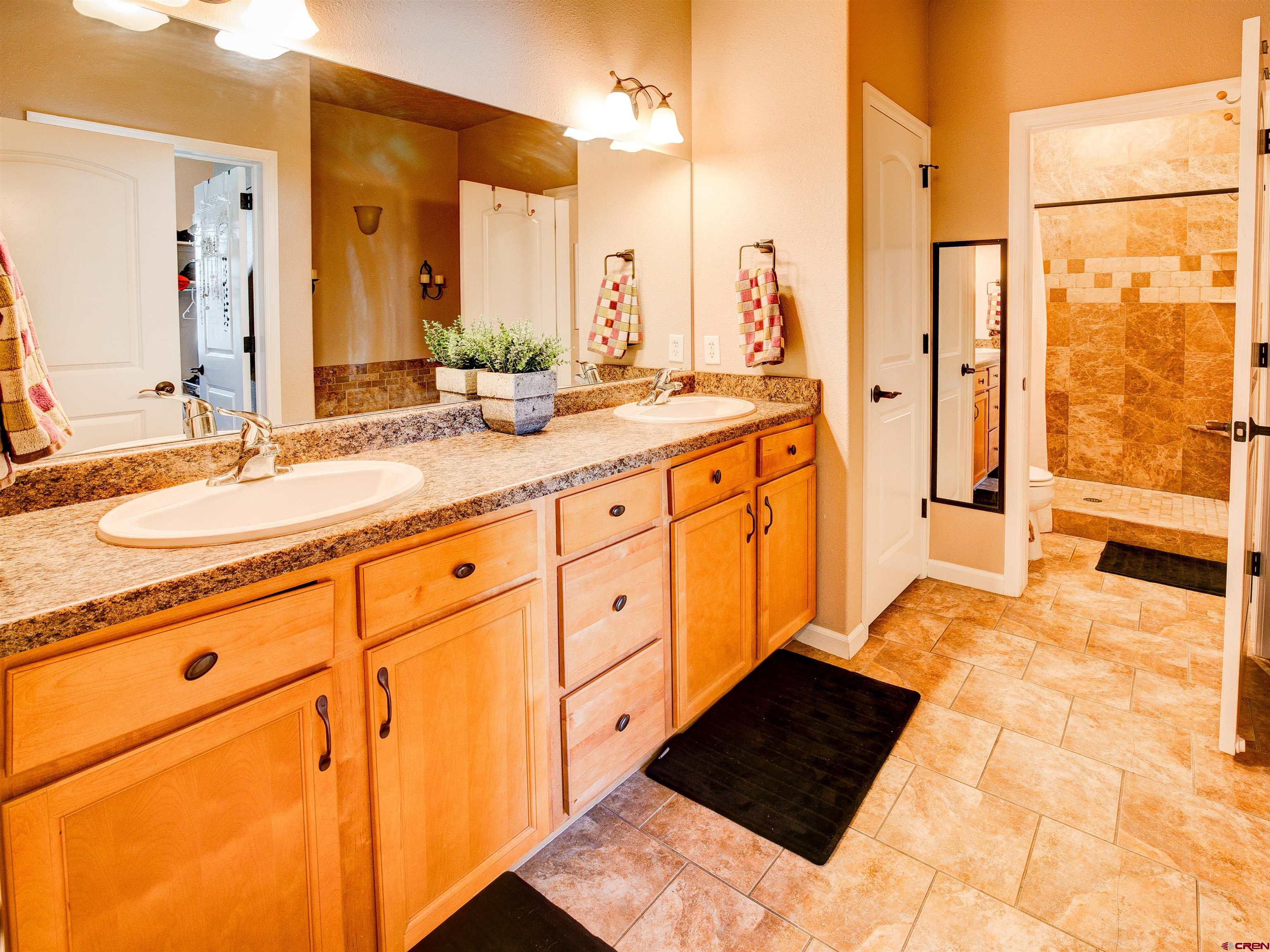 2942 F 1/4 Road Grand Junction, CO 81504 - Photo 17 of 32 a bathroom with a double vanity sink and mirror