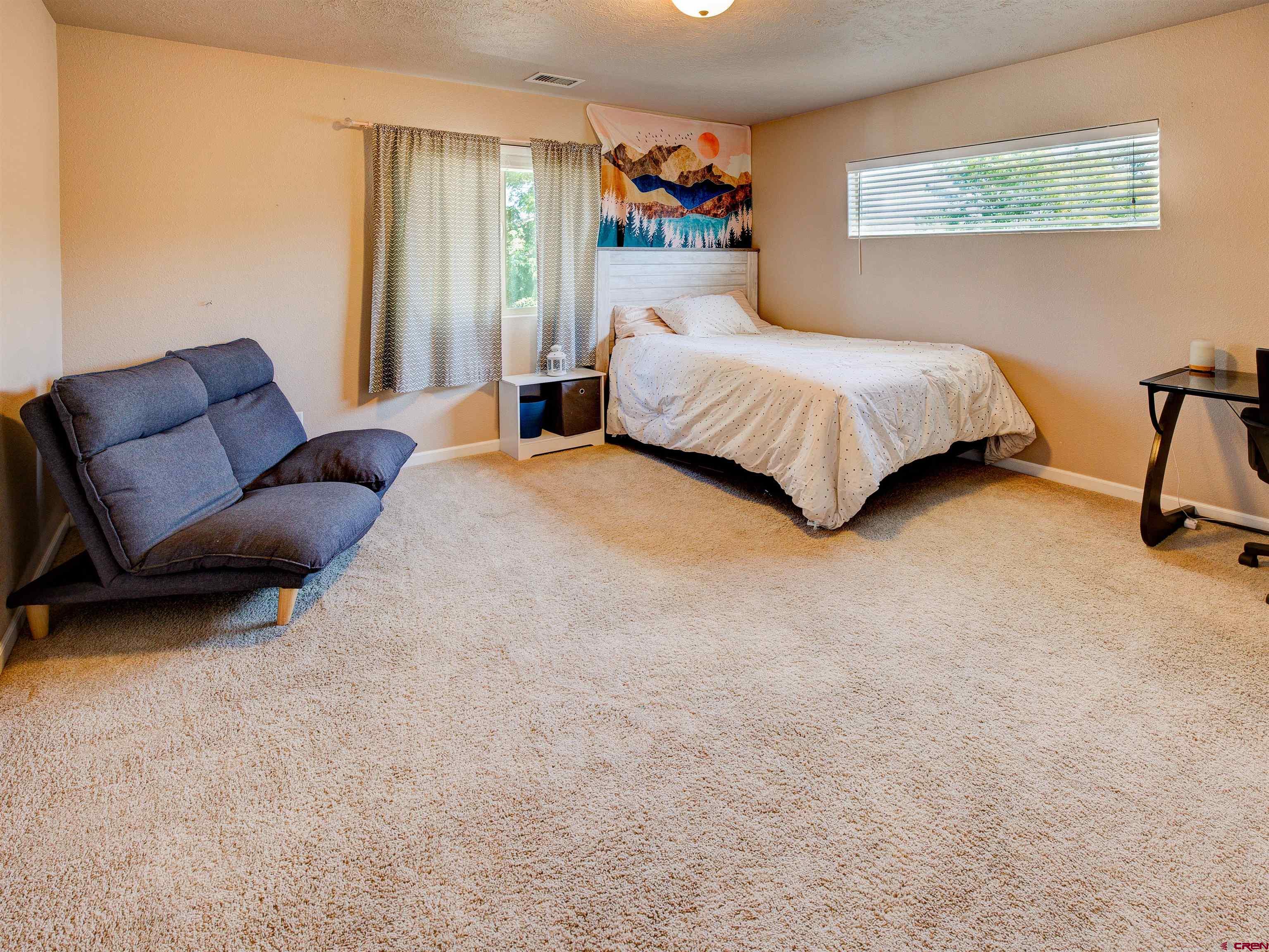 2942 F 1/4 Road Grand Junction, CO 81504 - Photo 21 of 32 a bedroom with a bed a couch and a window