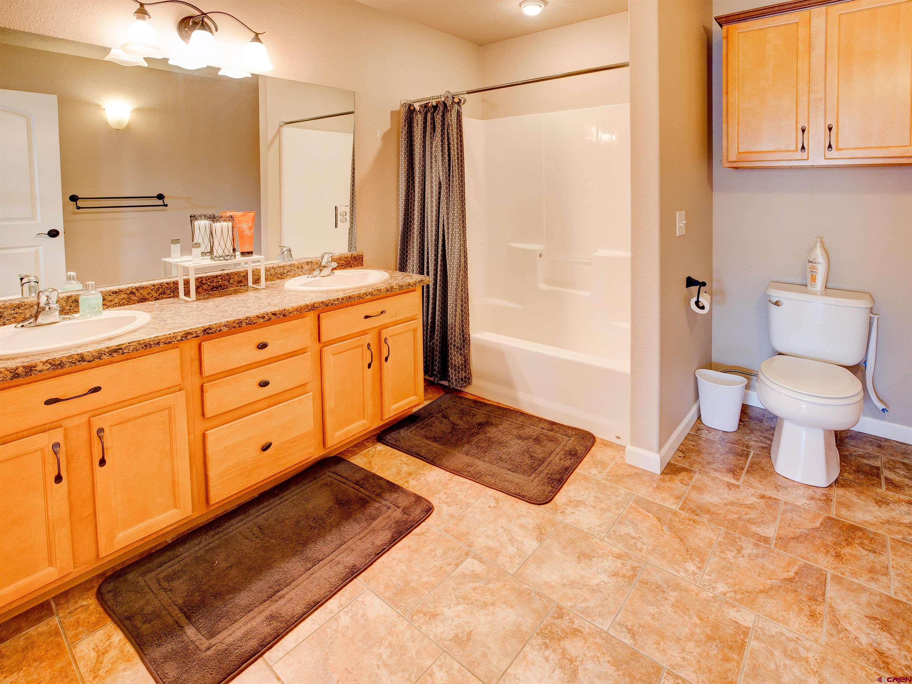 2942 F 1/4 Road Grand Junction, CO 81504 - Photo 23 of 32 a bathroom with a granite countertop sink mirror vanity and toilet