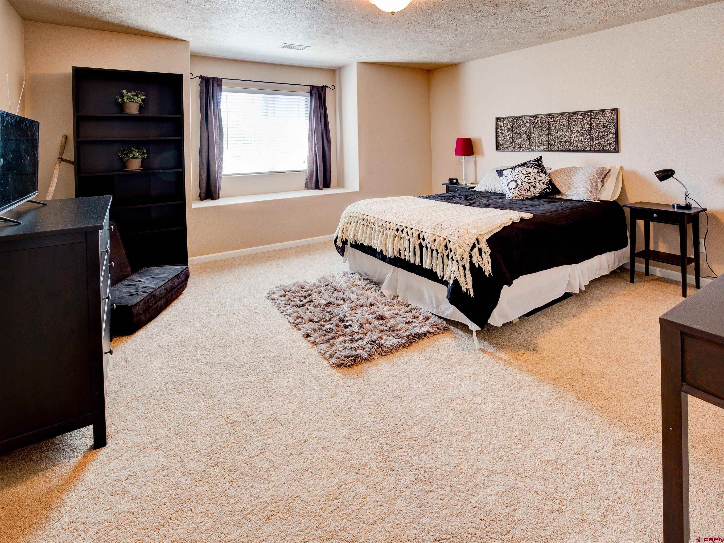 2942 F 1/4 Road Grand Junction, CO 81504 - Photo 24 of 32 a bedroom with a bed window and a television