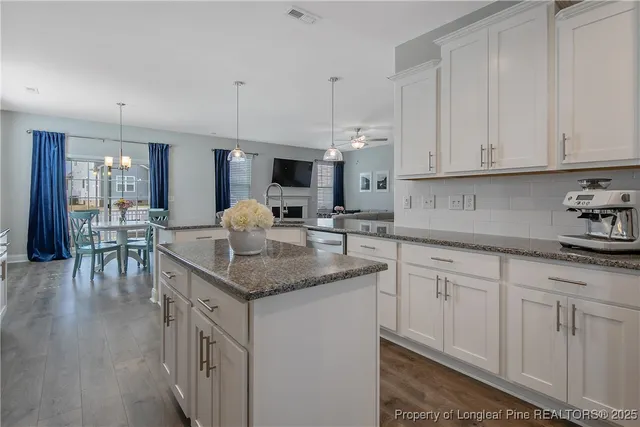 a kitchen with white cabinets and sink