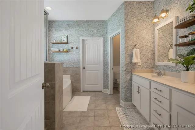 a bathroom with a double vanity sink a toilet a mirror and shower