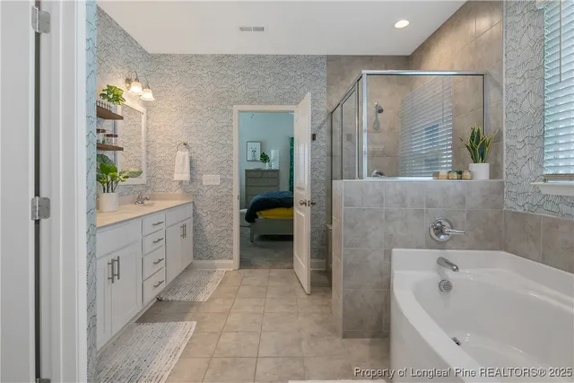 a spacious bathroom with a tub sink and mirror