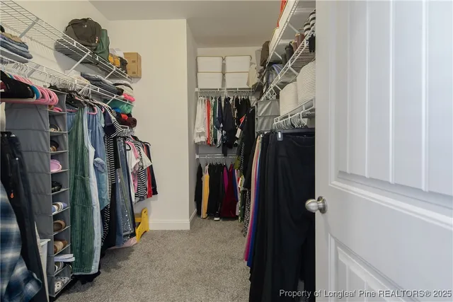 a view of walk in closet with clothes