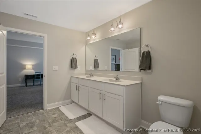 a bathroom with a toilet sink and mirror