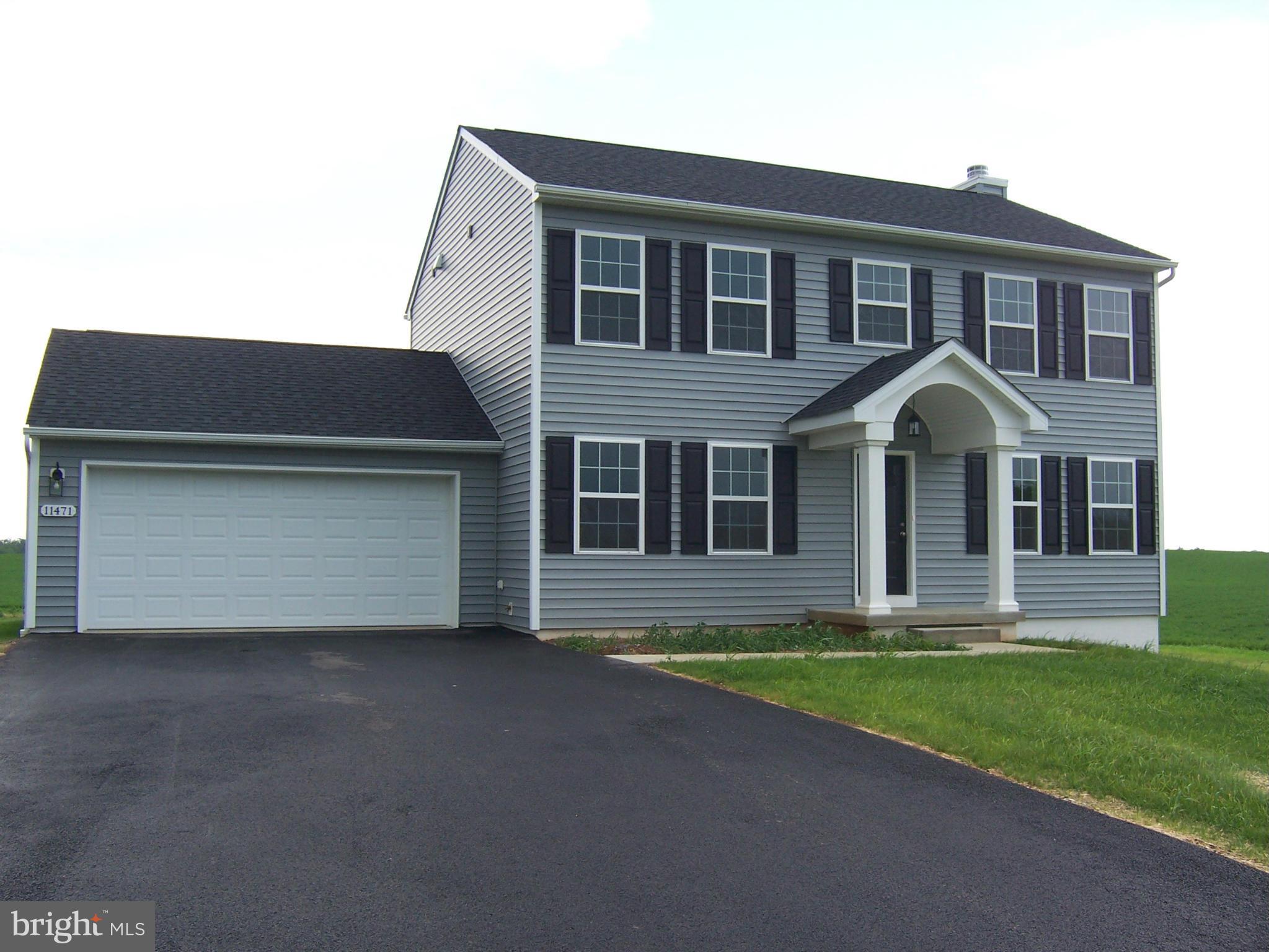 a front view of a house with a garden and yard