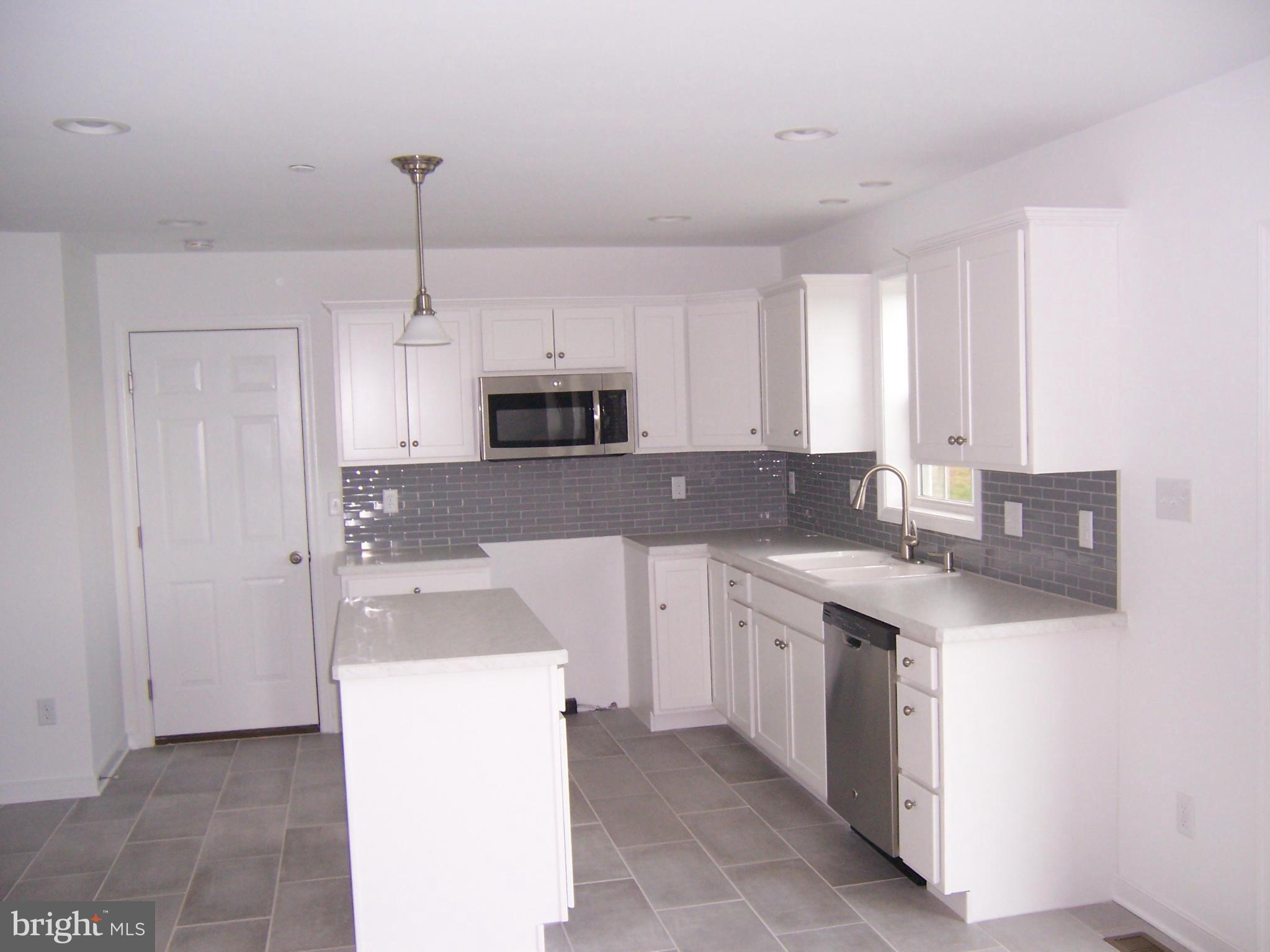 11741 Ashton Road Clear Spring, MD 21722 - Photo 3 of 9 a kitchen with kitchen island a sink appliances and cabinets