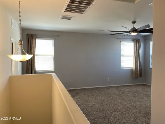 an empty room with a window and a fan