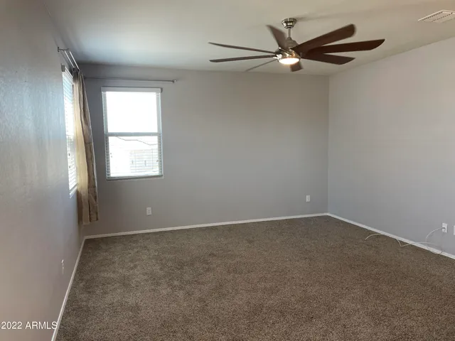 an empty room with a window and a fan