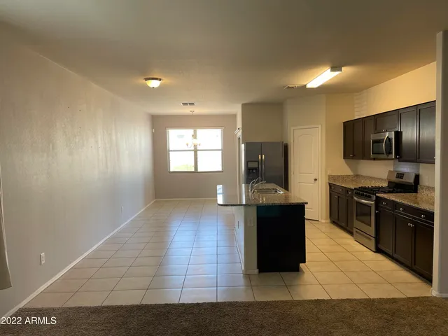 a kitchen with granite countertop a stove and a refrigerator