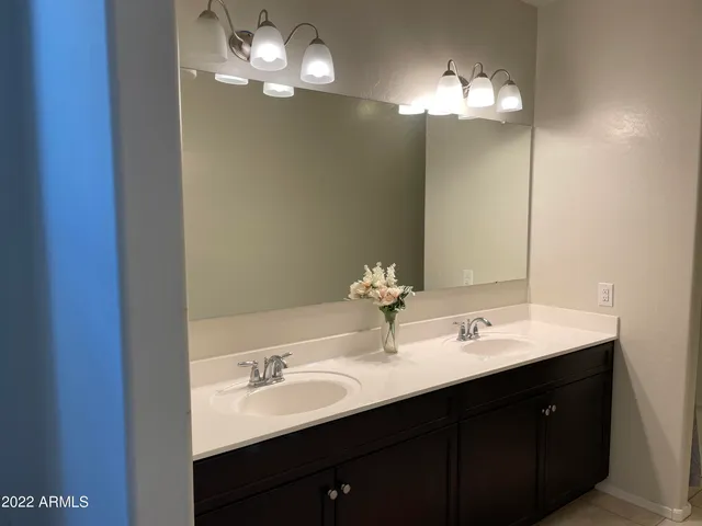 a bathroom with a double vanity sink and a mirror
