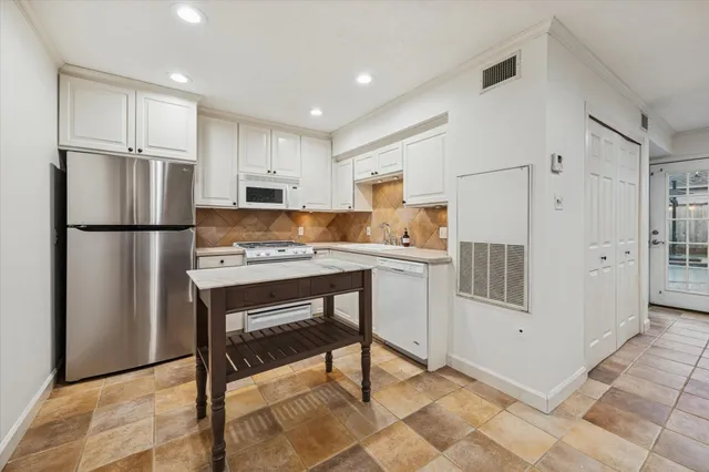a kitchen with a refrigerator a counter top space and cabinets