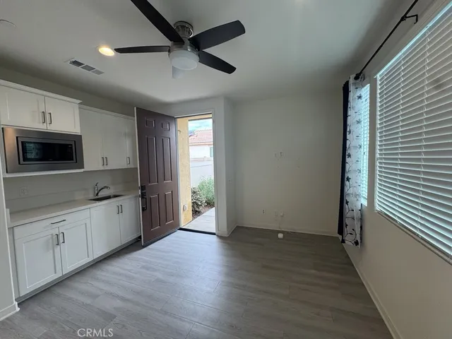 a large kitchen with a wooden floor and a ceiling fan