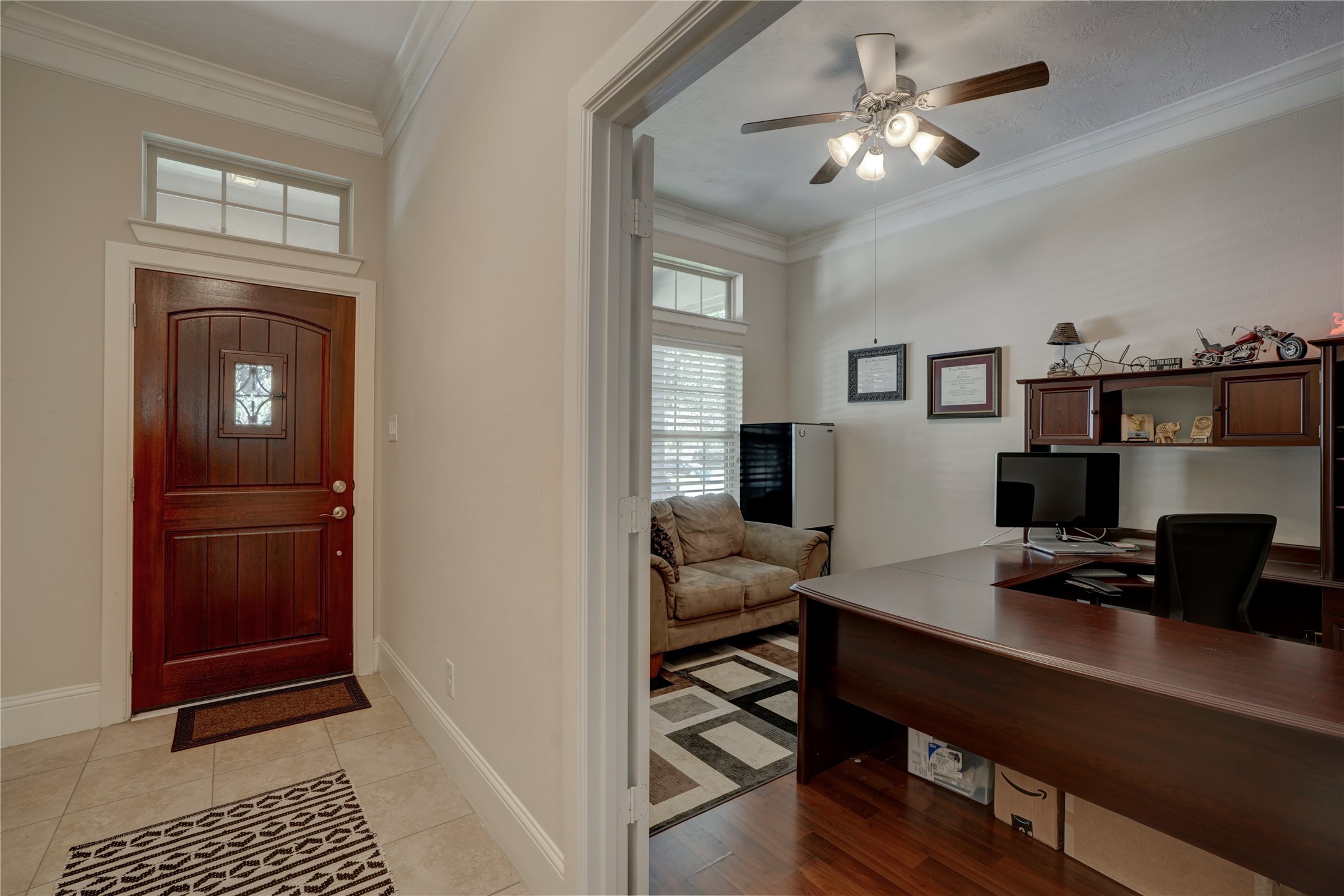 27243 Jessica Hills Lane Spring, TX 77386 - Photo 11 of 49 A welcoming entryway with a rich wooden door and tiled flooring. Adjacent is a cozy home office with natural light streaming through the windows.