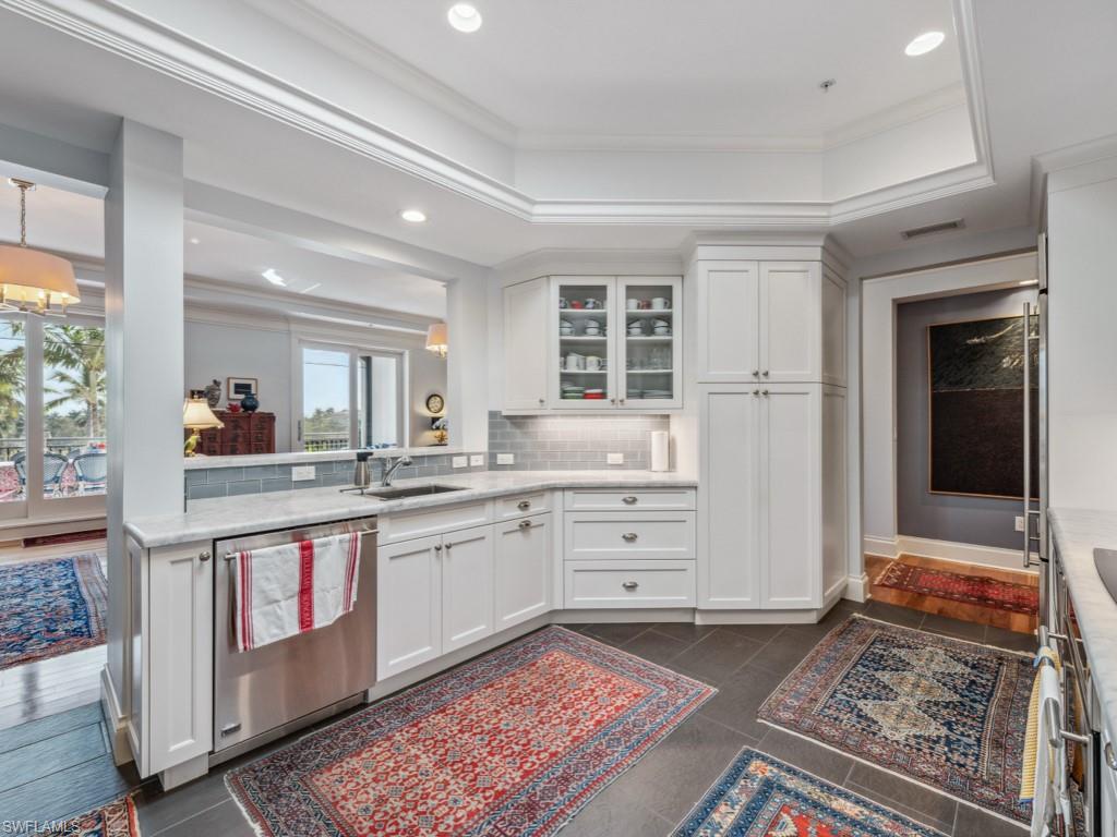 625 5th Avenue South, Unit PH302 Naples, FL 34102 - Photo 7 of 33 Renovated kitchen featuring backsplash, a raised ceiling, custom white cabinetry, and dishwasher