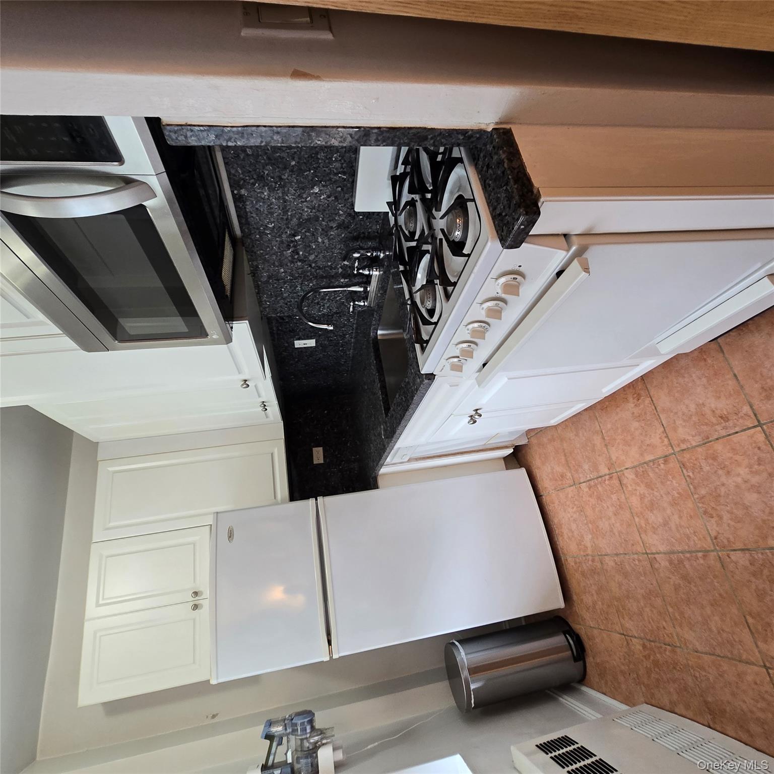 99-40 63rd Road, Unit 1O Queens, NY 11374 - Photo 9 of 14 a kitchen with a stove and a microwave