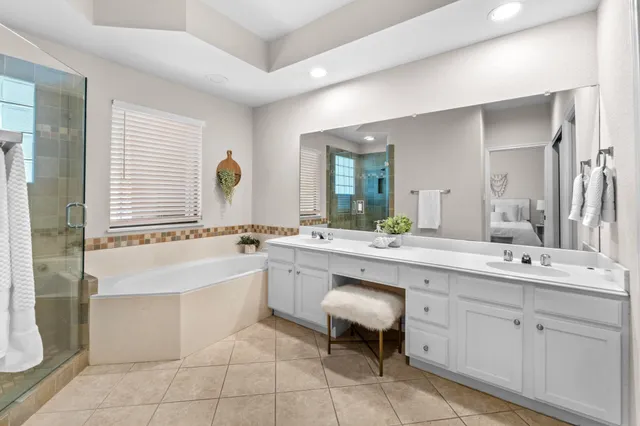 a large bathroom with a double vanity sink a mirror and a bathtub