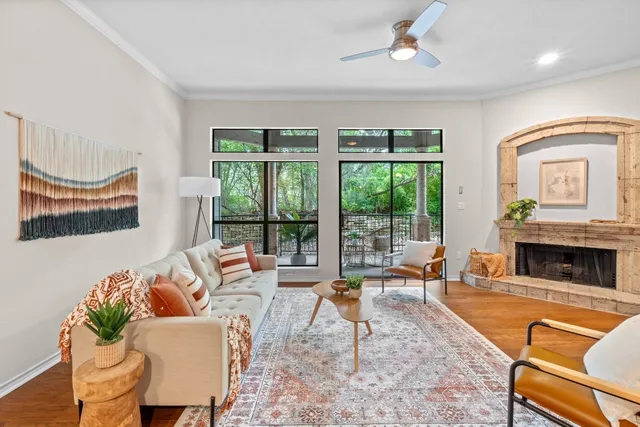 a living room with furniture a fireplace and a floor to ceiling window