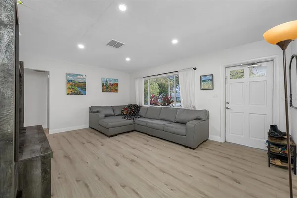 a living room with furniture and a wooden floor