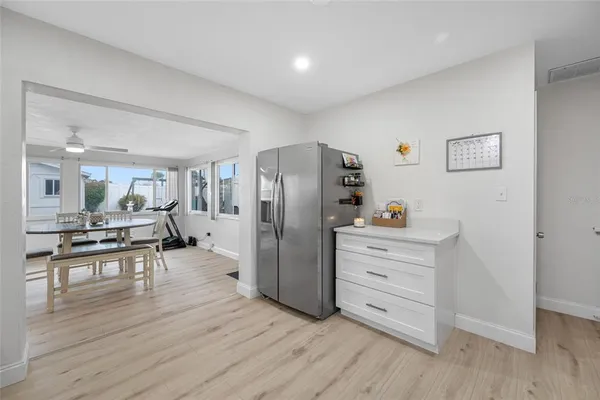 a kitchen with stainless steel appliances a refrigerator and wooden floor