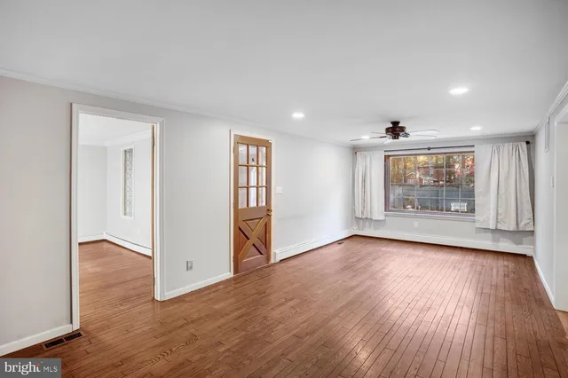a view of empty room with wooden floor and fireplace