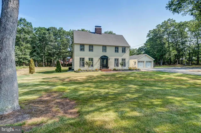a view of a house with a big yard and large trees