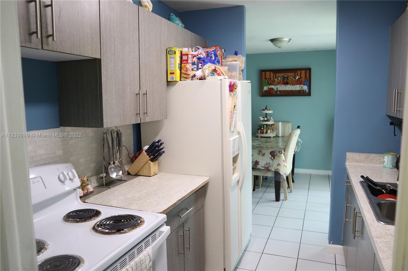 15261 Southwest 303rd Street Homestead, FL 33033 - Photo 7 of 23 a kitchen with a stove a refrigerator and a table