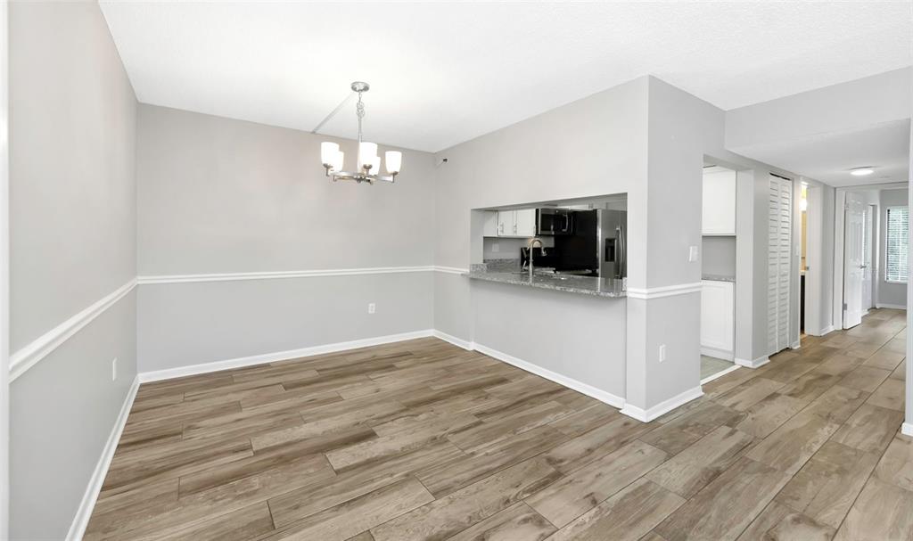 1308 Pine Ridge Circle East, Unit H1 Tarpon Springs, FL 34688 - Photo 14 of 50 a view of a livingroom with wooden floor and a kitchen space