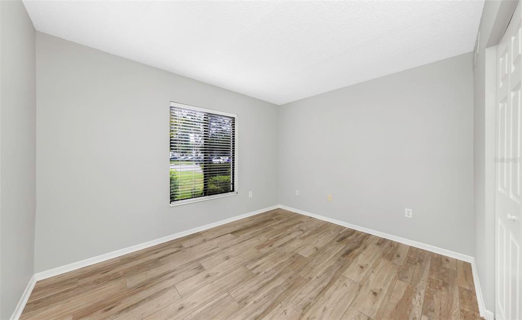 1308 Pine Ridge Circle East, Unit H1 Tarpon Springs, FL 34688 - Photo 18 of 50 an empty room with wooden floor and windows