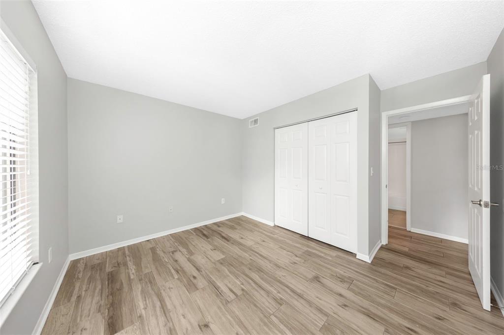 1308 Pine Ridge Circle East, Unit H1 Tarpon Springs, FL 34688 - Photo 19 of 50 an empty room with wooden floor and windows