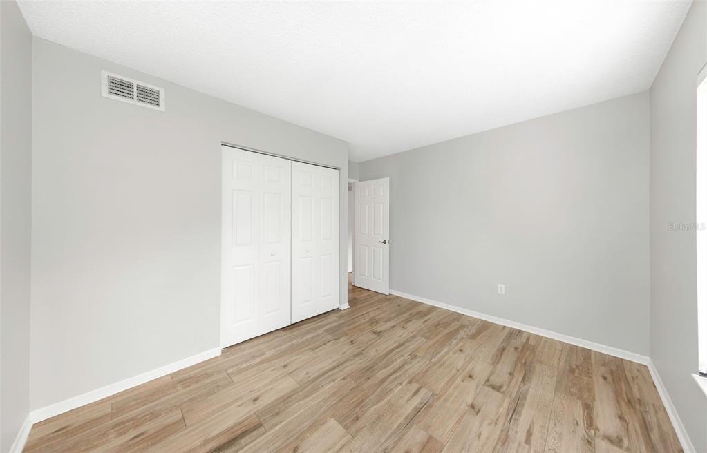 1308 Pine Ridge Circle East, Unit H1 Tarpon Springs, FL 34688 - Photo 20 of 50 a view of an empty room with wooden floor