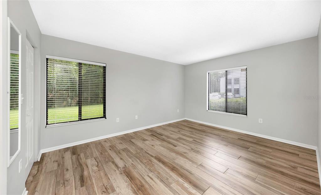 1308 Pine Ridge Circle East, Unit H1 Tarpon Springs, FL 34688 - Photo 21 of 50 a view of an empty room with wooden floor and a window
