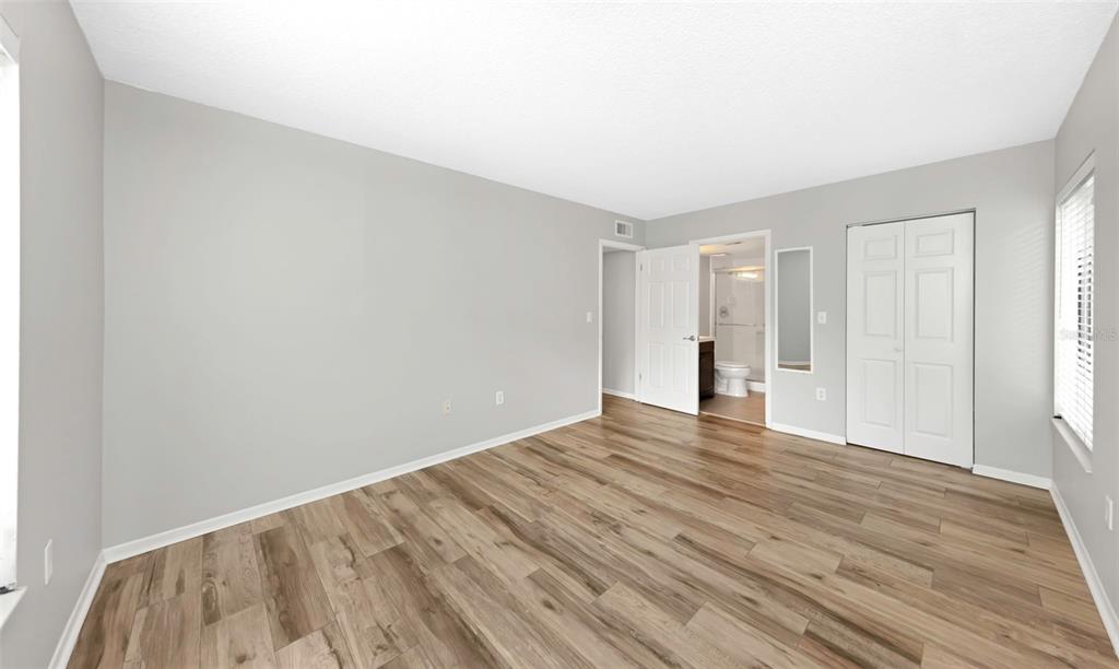 1308 Pine Ridge Circle East, Unit H1 Tarpon Springs, FL 34688 - Photo 22 of 50 a view of an empty room with wooden floor and a window