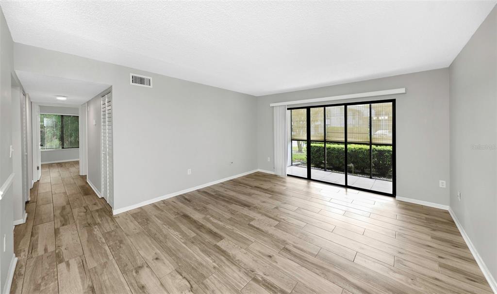1308 Pine Ridge Circle East, Unit H1 Tarpon Springs, FL 34688 - Photo 9 of 50 wooden floor in an empty room with a window