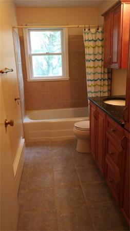 69 Ardmore Road Framingham, MA 01702 - Photo 16 of 30 a bathroom with a granite countertop toilet a sink and a bathtub