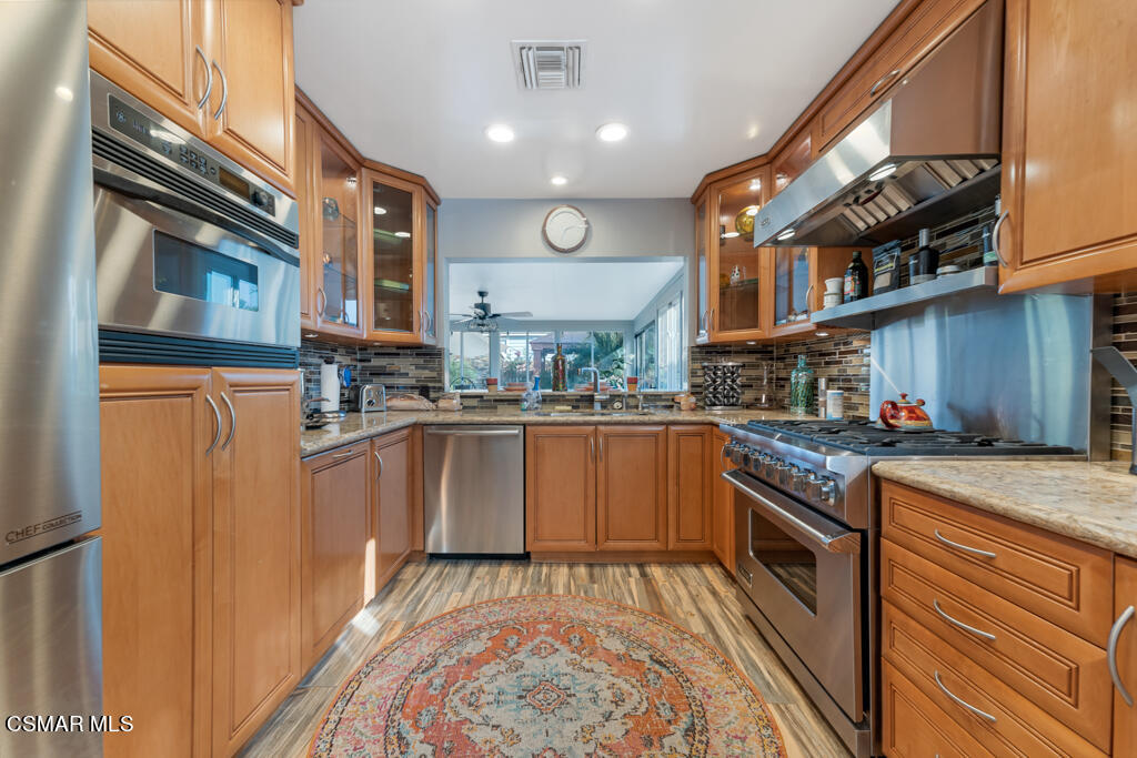 24 Kanan Road Oak Park, CA 91377 - Photo 10 of 20 a kitchen with stainless steel appliances granite countertop a stove and cabinets