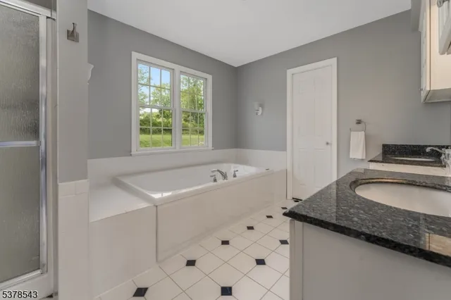a bathroom with a granite countertop sink a toilet and mirror