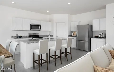 a kitchen with stainless steel appliances granite countertop a refrigerator a stove a microwave a dining table and chairs